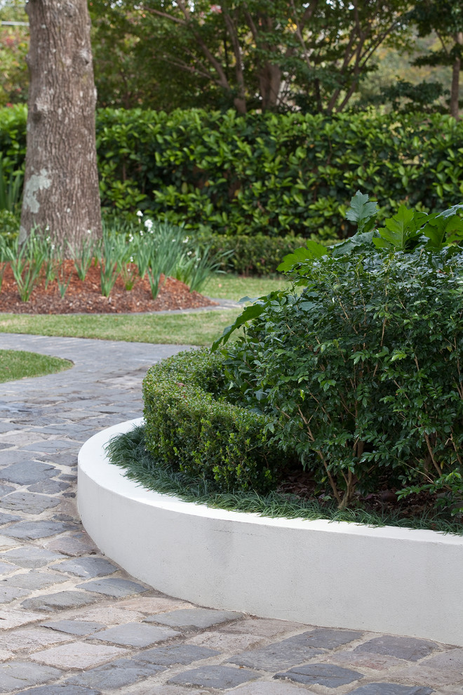 This is an example of a large traditional partial sun front yard stone landscaping in Sydney.