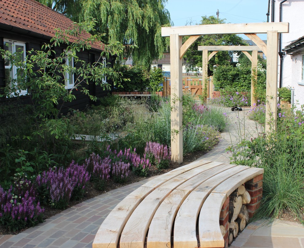 Diseño de jardín clásico de tamaño medio en patio trasero con jardín francés, exposición total al sol y adoquines de piedra natural