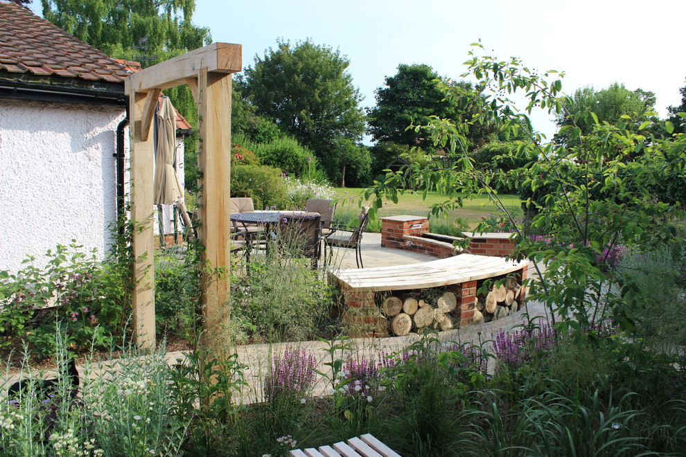 Geometrische, Mittelgroße Klassische Gartenmauer hinter dem Haus mit direkter Sonneneinstrahlung und Natursteinplatten in Hertfordshire