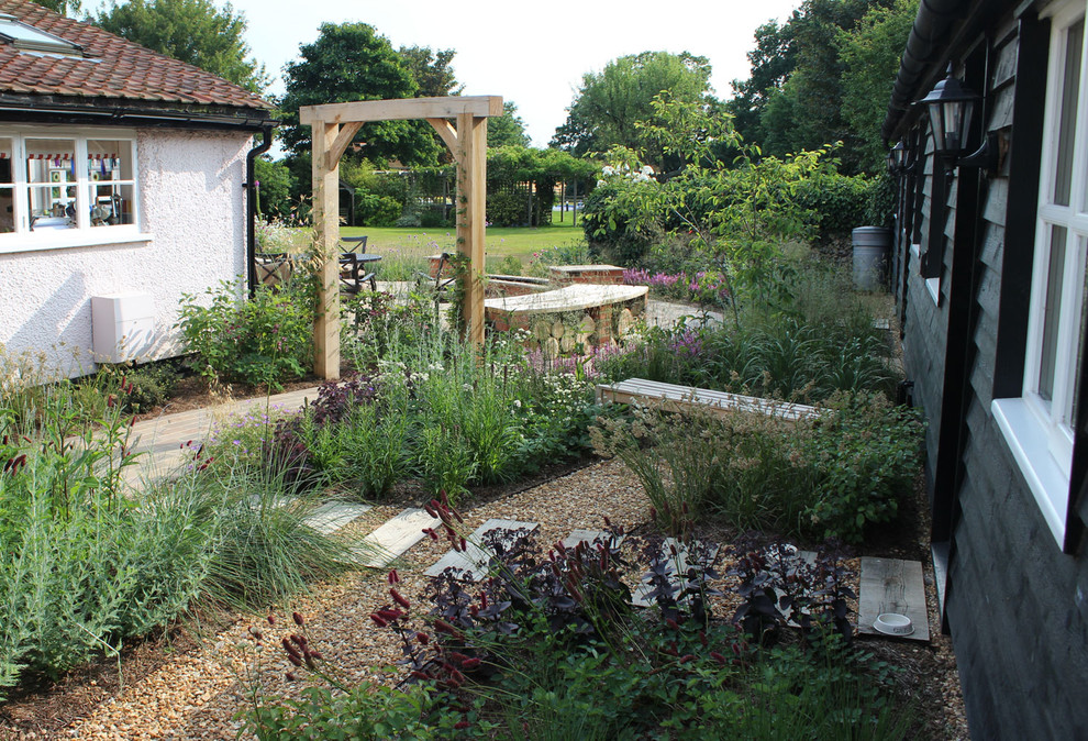 This is an example of a medium sized back formal garden in Hertfordshire with a garden path.