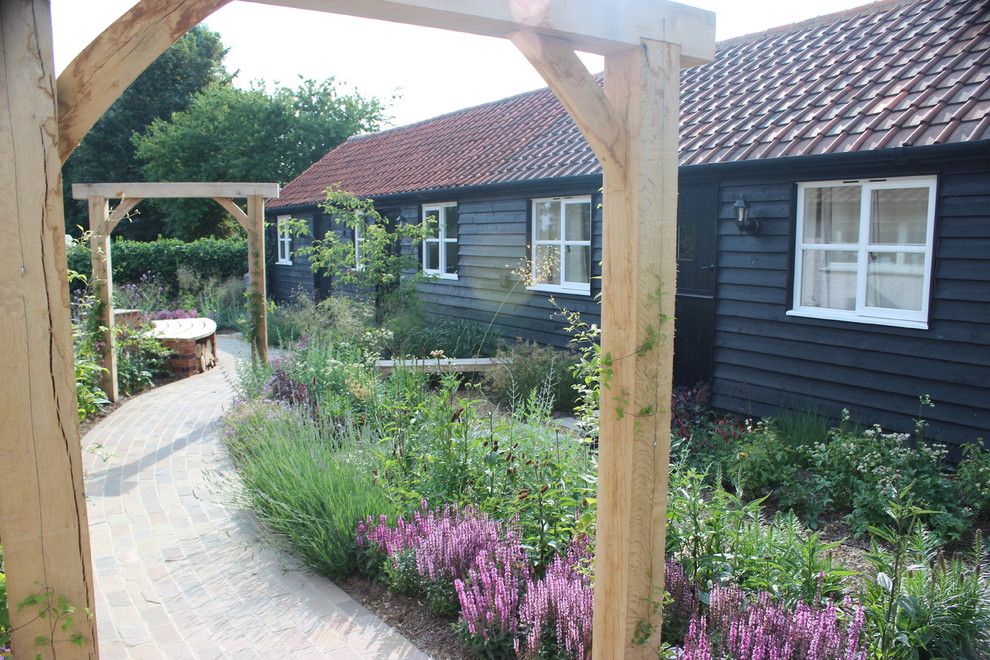 Geometrischer, Mittelgroßer Klassischer Gartenweg hinter dem Haus mit direkter Sonneneinstrahlung und Natursteinplatten in Hertfordshire