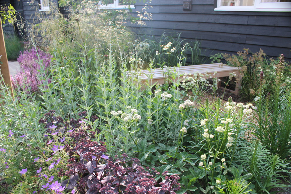Modelo de jardín tradicional de tamaño medio en patio trasero con jardín francés, exposición total al sol, gravilla y jardín de macetas