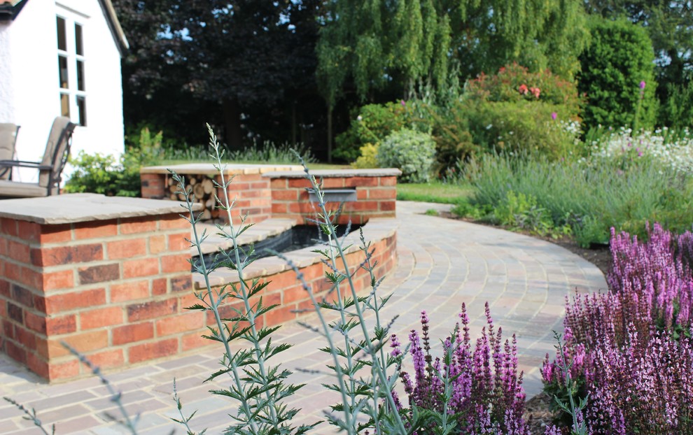 Diseño de camino de jardín clásico de tamaño medio en patio trasero con jardín francés, exposición total al sol y adoquines de piedra natural