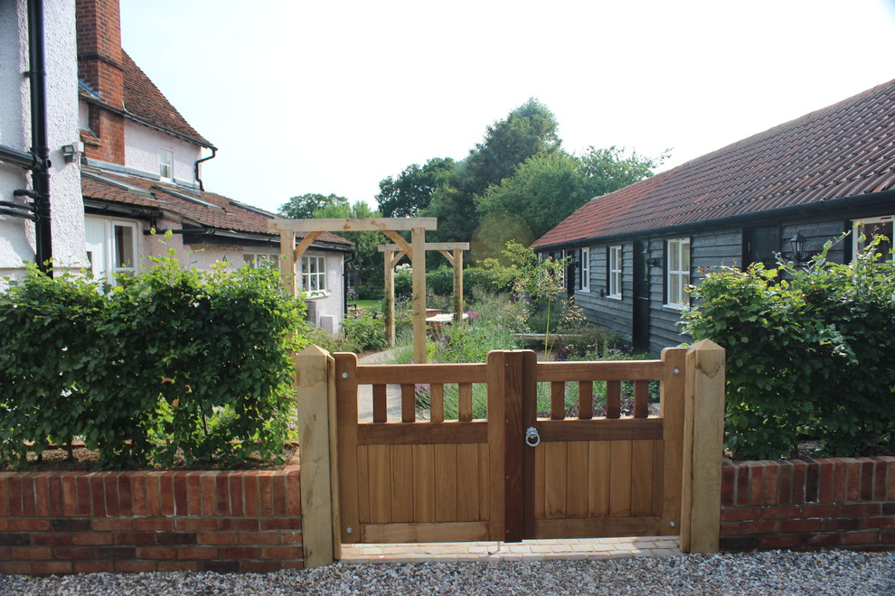 This is an example of a classic back full sun garden in Hertfordshire with an outdoor sport court and brick paving.
