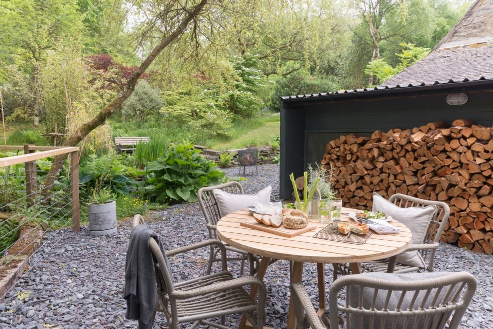 Inspiration for a mid-sized rustic backyard gravel landscaping in Glasgow.