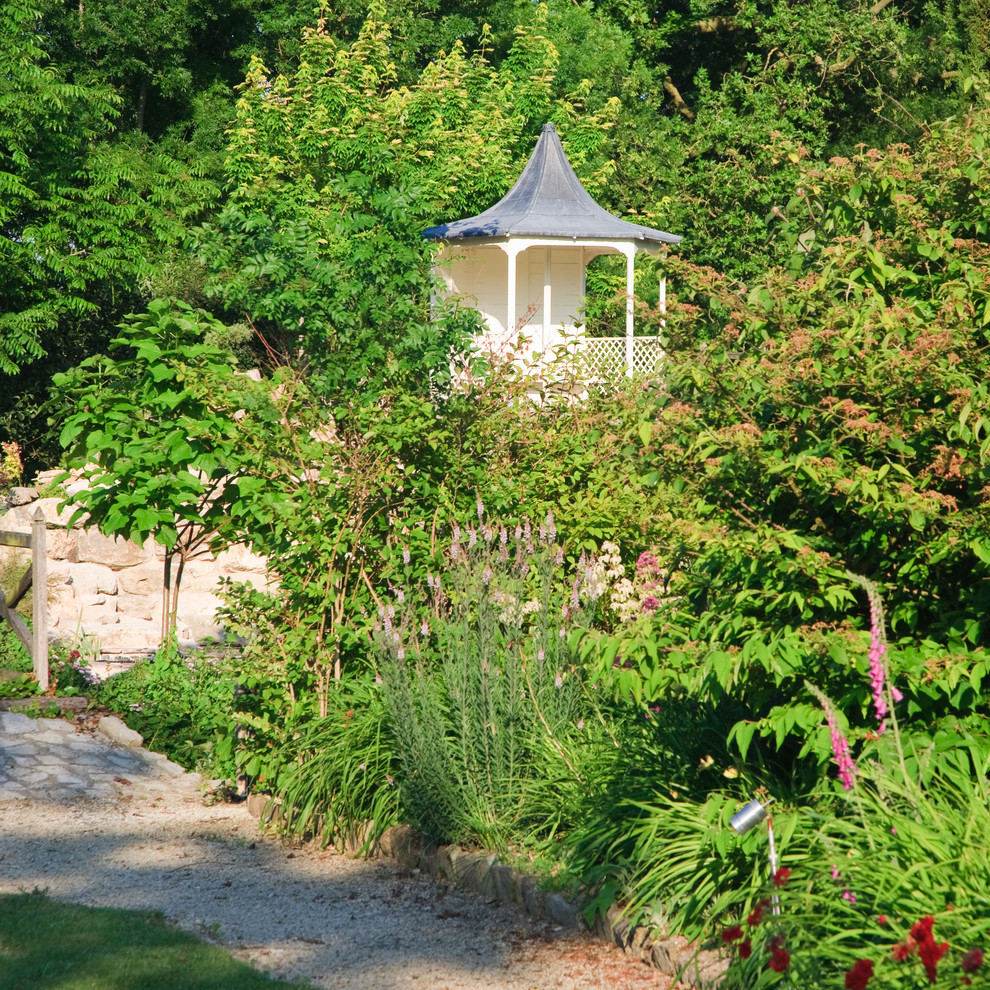 Esempio di un giardino classico con un muro di contenimento e gazebo