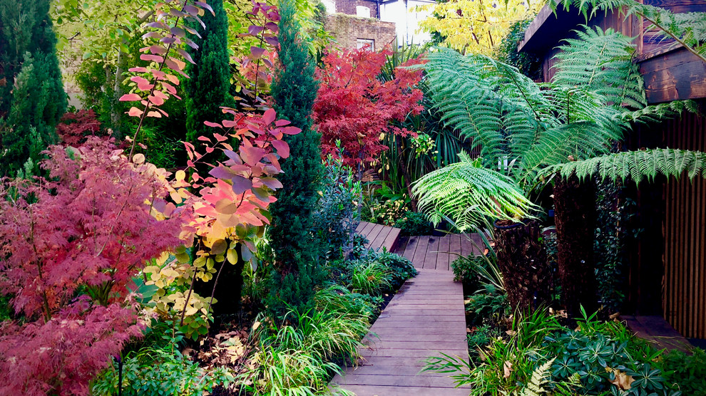 Aménagement d'un grand jardin arrière exotique avec une terrasse en bois.