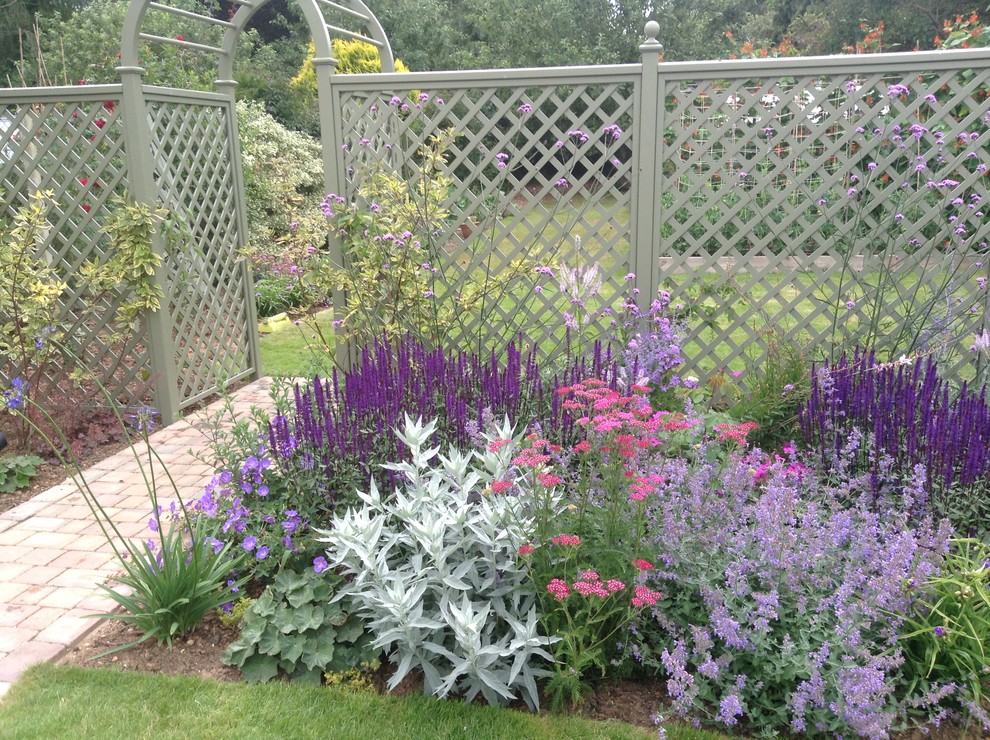 Long garden with trellis divider and rose arch Traditional