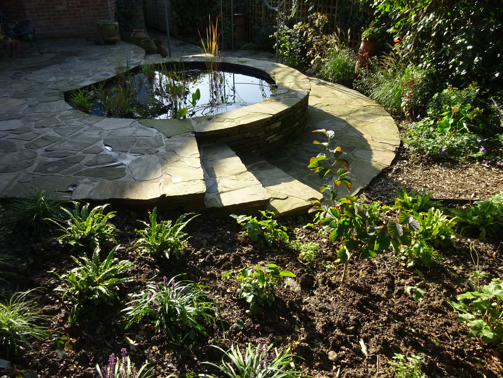 Idee per un laghetto da giardino moderno esposto a mezz'ombra di medie dimensioni e dietro casa con pavimentazioni in pietra naturale