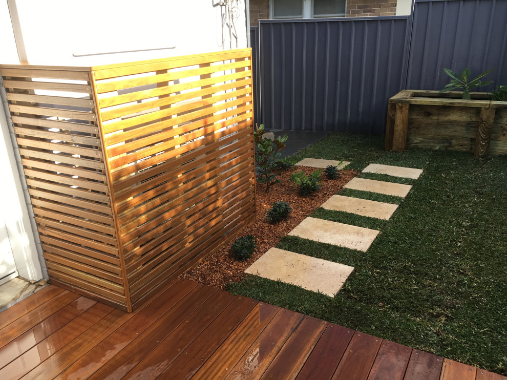 Пример оригинального дизайна: маленький солнечный регулярный сад на заднем дворе в стиле модернизм с садовой дорожкой или калиткой, хорошей освещенностью и покрытием из каменной брусчатки для на участке и в саду