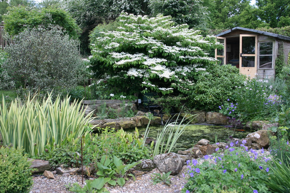 Inspiration för en eklektisk trädgård i full sol, med en fontän och grus