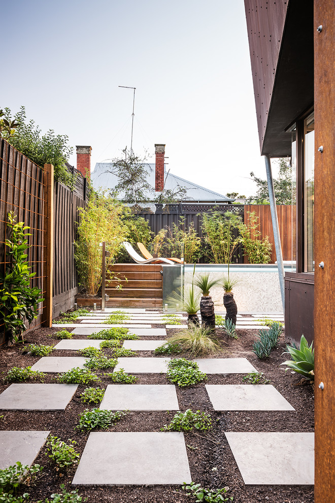 На фото: солнечный, летний регулярный сад среднего размера на заднем дворе в современном стиле с хорошей освещенностью и мощением тротуарной плиткой