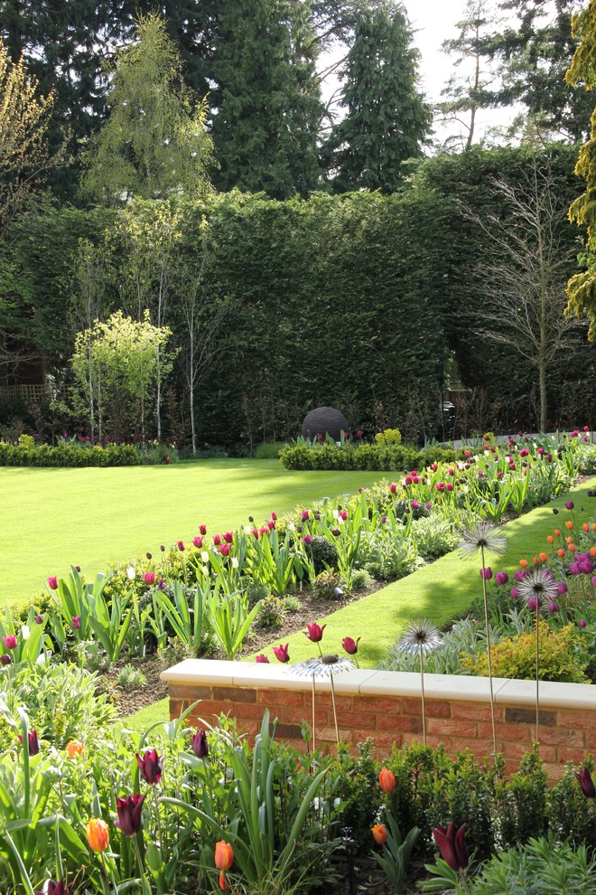 Geräumiger Moderner Garten hinter dem Haus mit direkter Sonneneinstrahlung und Natursteinplatten in Hertfordshire
