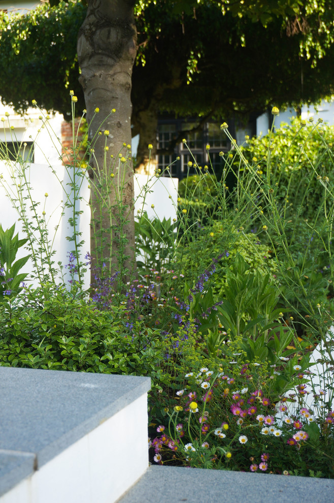 Geometrischer, Kleiner, Halbschattiger Moderner Garten im Innenhof im Sommer mit Feuerstelle und Natursteinplatten in London
