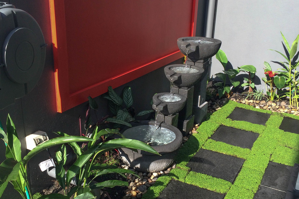 Esempio di un piccolo giardino formale tropicale esposto in pieno sole in cortile con fontane e pavimentazioni in pietra naturale