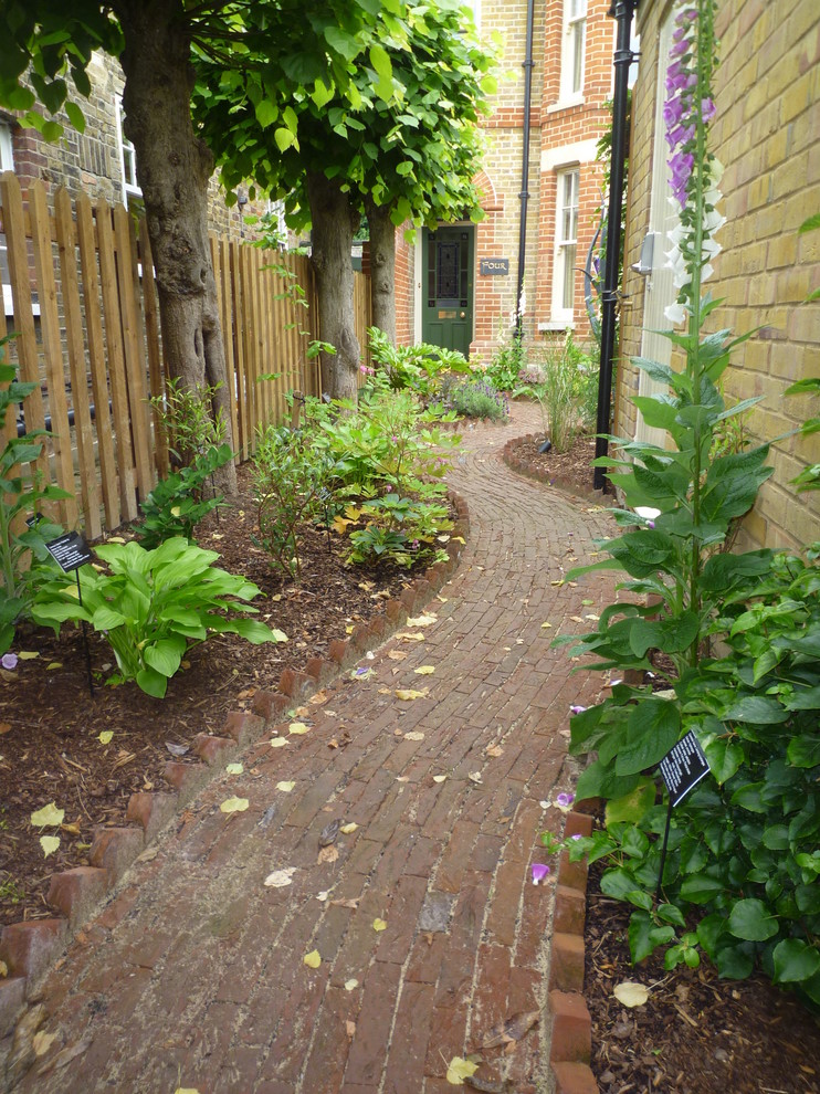 Foto de camino de jardín clásico de tamaño medio en patio trasero con jardín francés, exposición reducida al sol y adoquines de ladrillo