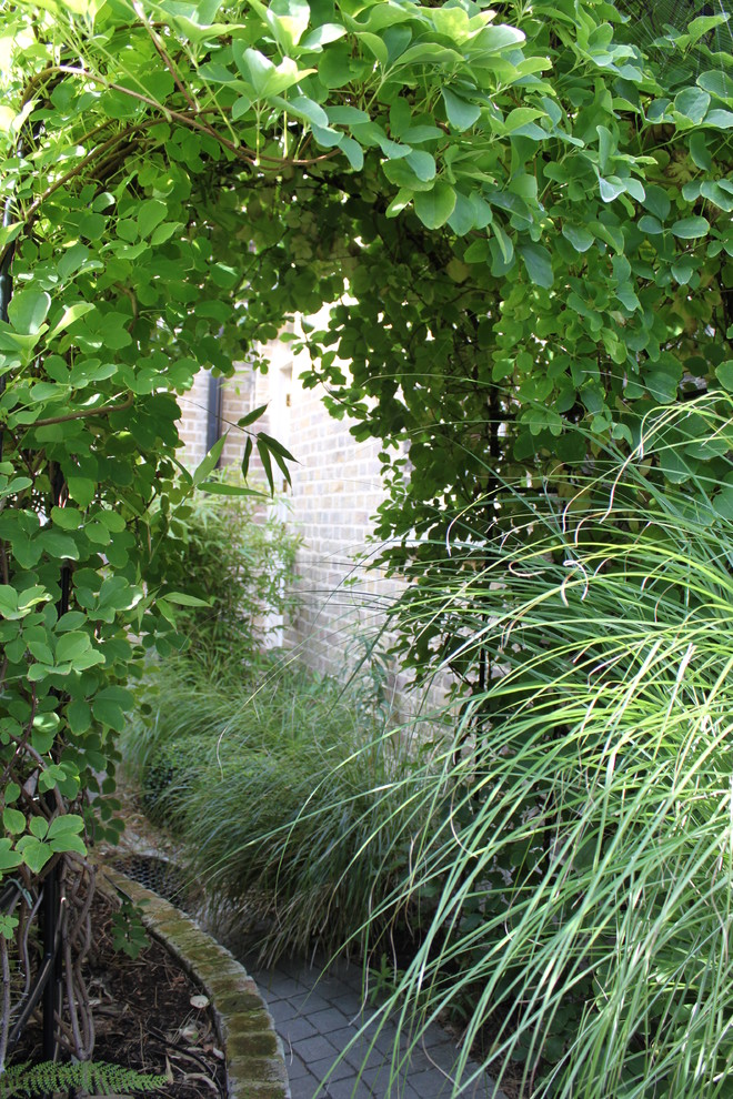 Aménagement d'un petit jardin arrière contemporain avec des pavés en pierre naturelle.