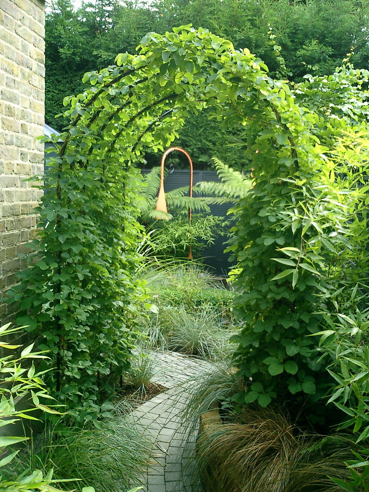 Cette image montre un petit jardin arrière design avec des pavés en brique.
