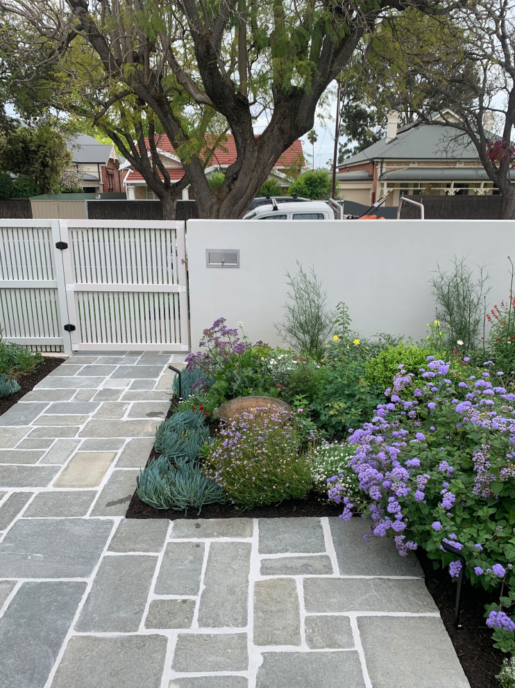 Immagine di un giardino minimalista esposto in pieno sole di medie dimensioni e davanti casa in primavera con un ingresso o sentiero, pavimentazioni in pietra naturale e recinzione in legno