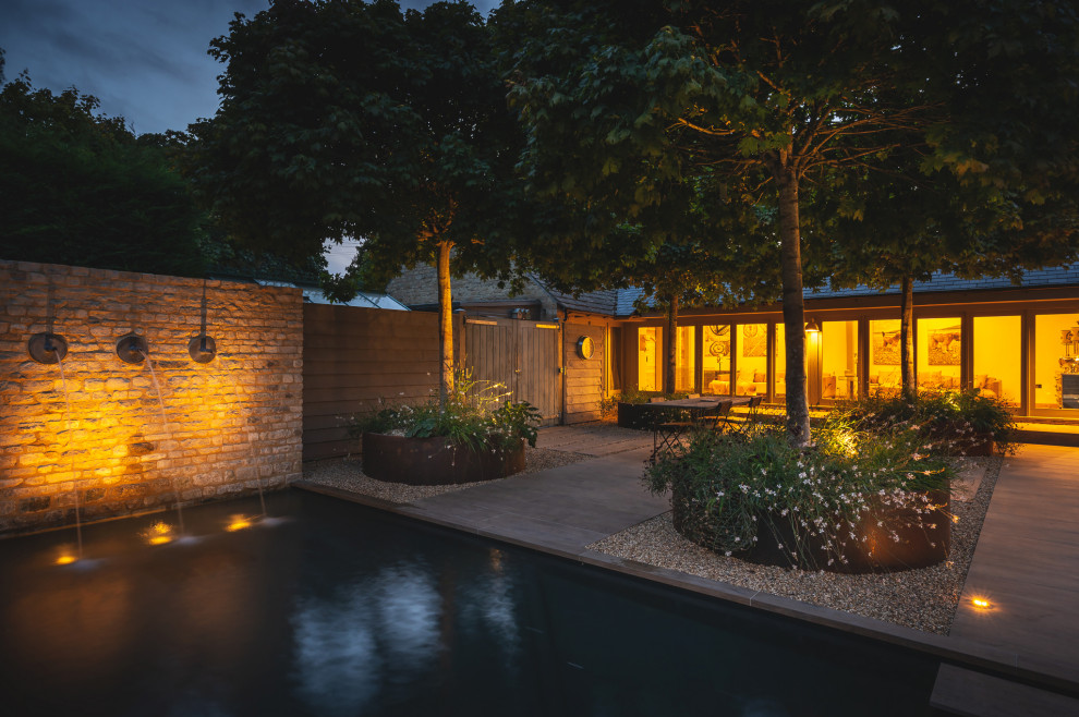 Design ideas for a small contemporary courtyard formal full sun garden for summer in Oxfordshire with a waterfall.
