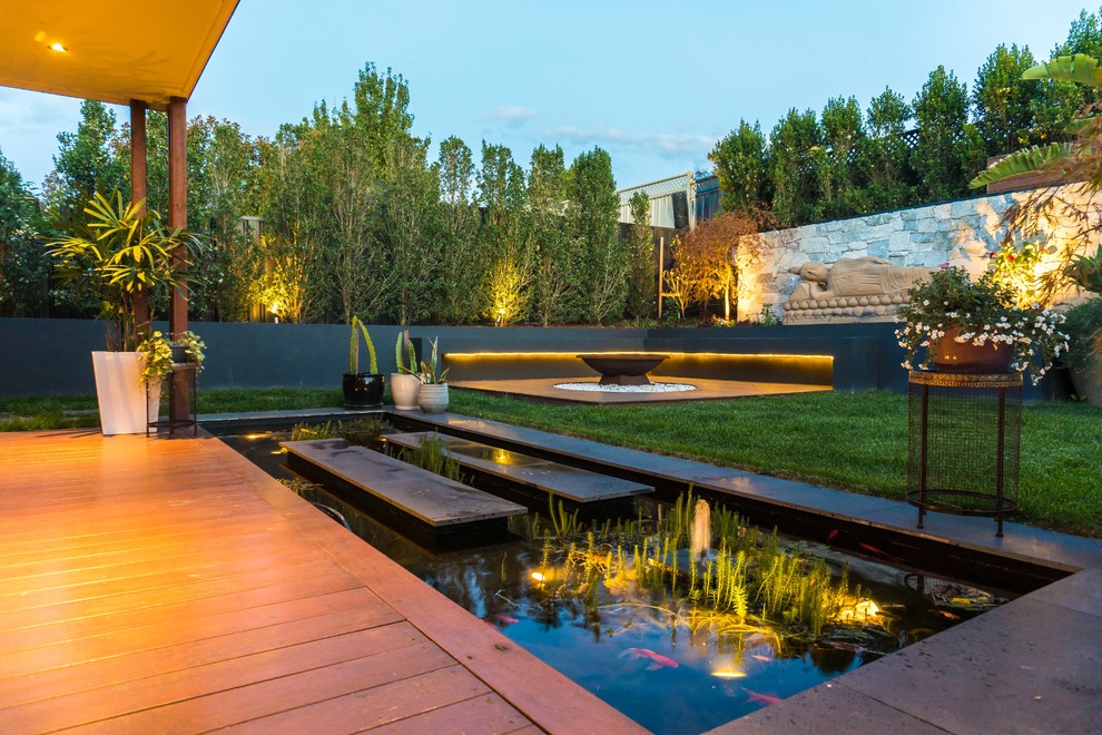This is an example of a contemporary full sun pond in Melbourne with decking.