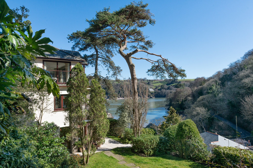 Mittelgroßer, Halbschattiger Klassischer Garten im Frühling, neben dem Haus mit Wasserspiel in Devon