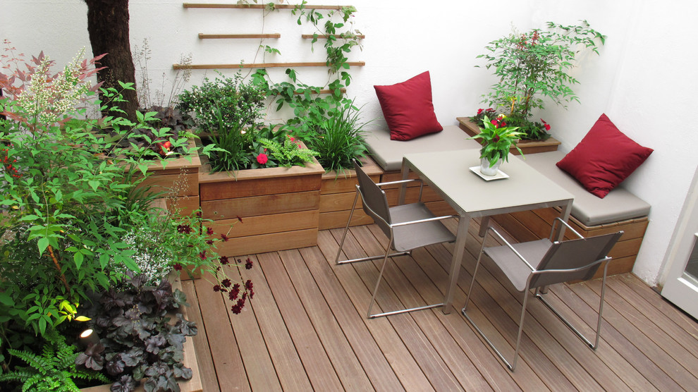 Kleiner, Halbschattiger Moderner Garten im Innenhof im Sommer mit Kübelpflanzen und Dielen in London