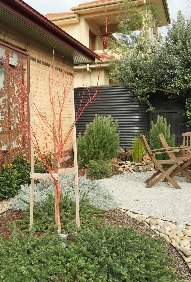 Пример оригинального дизайна: солнечный засухоустойчивый сад среднего размера на переднем дворе в стиле модернизм с хорошей освещенностью, покрытием из гравия и местом для костра