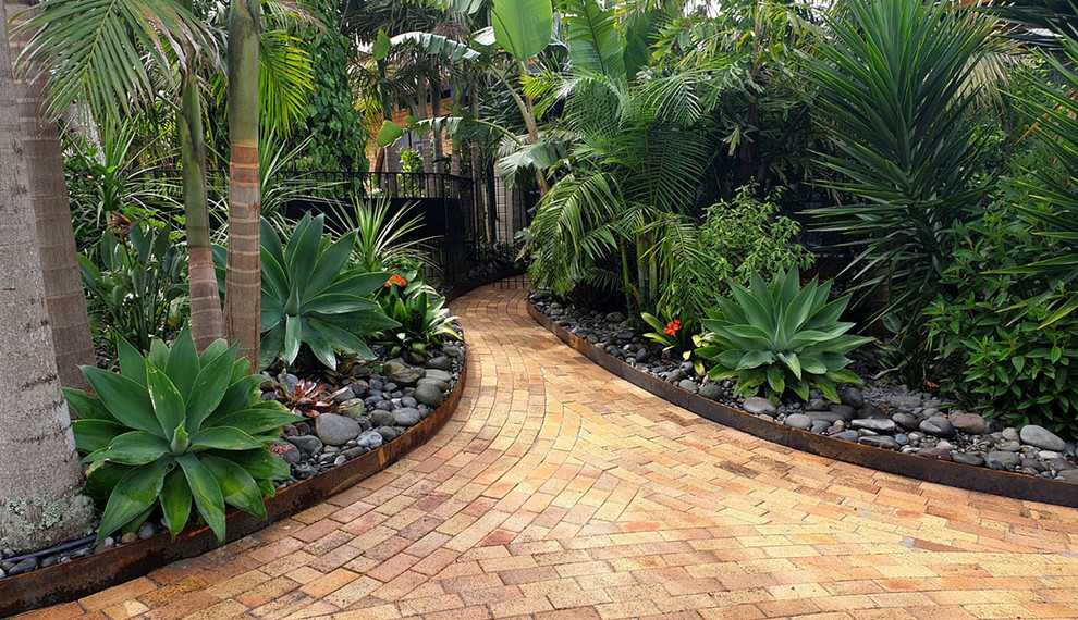 Immagine di un giardino minimal esposto in pieno sole di medie dimensioni e dietro casa in estate con un ingresso o sentiero e pavimentazioni in mattoni
