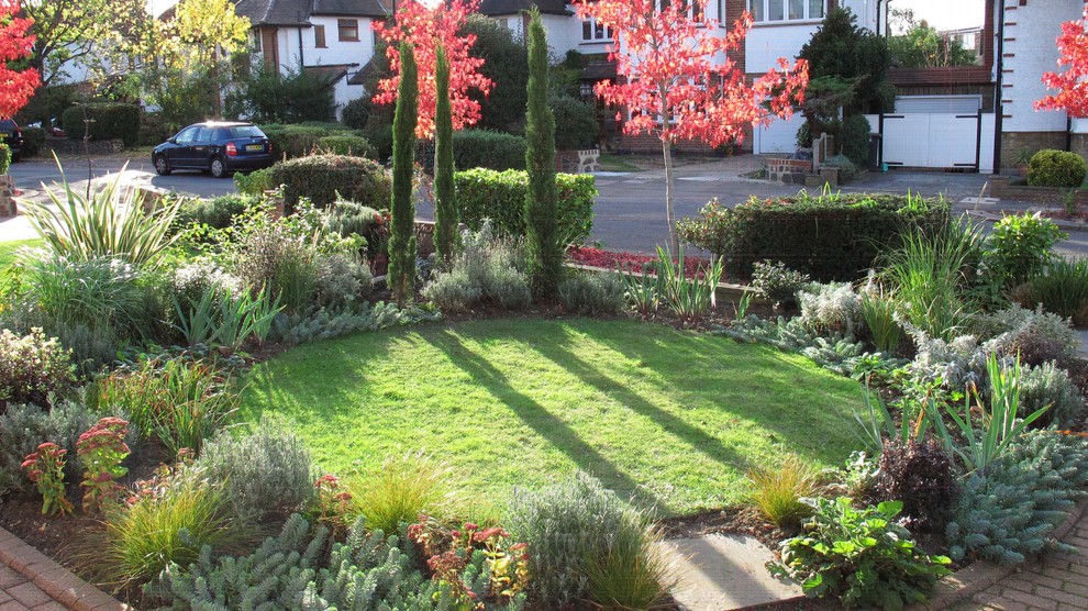 Пример оригинального дизайна: маленький солнечный, осенний засухоустойчивый сад на переднем дворе в средиземноморском стиле с хорошей освещенностью и мощением тротуарной плиткой для на участке и в саду