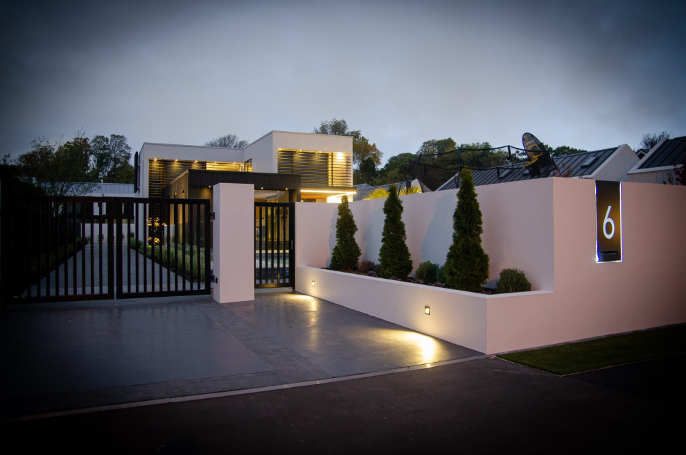 Modelo de acceso privado moderno de tamaño medio en patio delantero con portón y adoquines de piedra natural