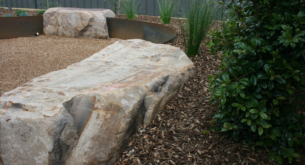 Inspiration for a small rustic full sun courtyard gravel retaining wall landscape in Melbourne for summer.