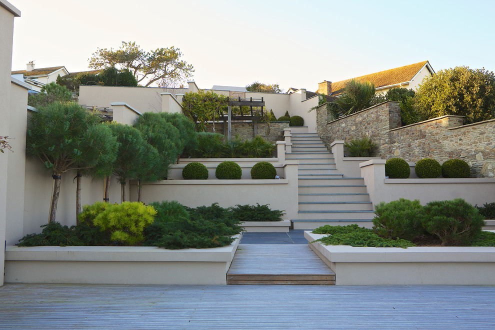 На фото: регулярный сад среднего размера на заднем дворе в стиле неоклассика (современная классика) с настилом и с перголой с