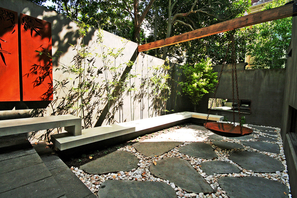 Foto på en liten funkis trädgård i delvis sol, med naturstensplattor