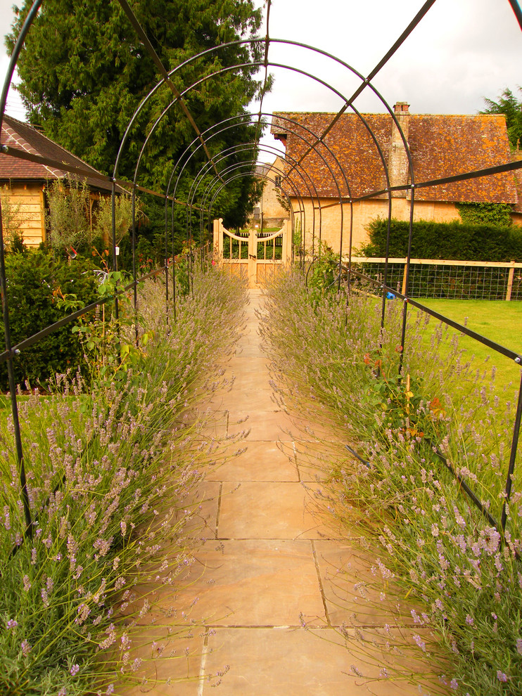 Landhausstil Gartenweg mit direkter Sonneneinstrahlung und Natursteinplatten in Dorset