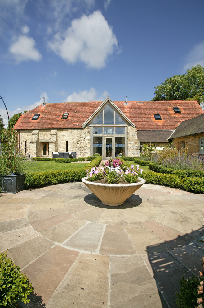 Landhaus Garten mit direkter Sonneneinstrahlung und Natursteinplatten in Dorset