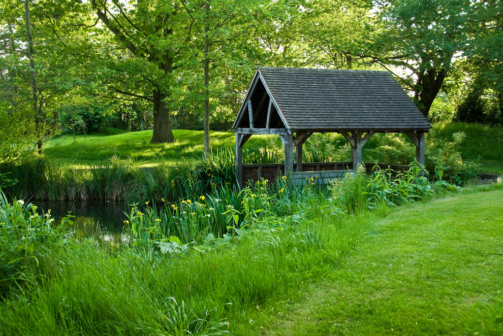 Cette image montre un très grand jardin arrière traditionnel l'été avec un point d'eau et une exposition partiellement ombragée.
