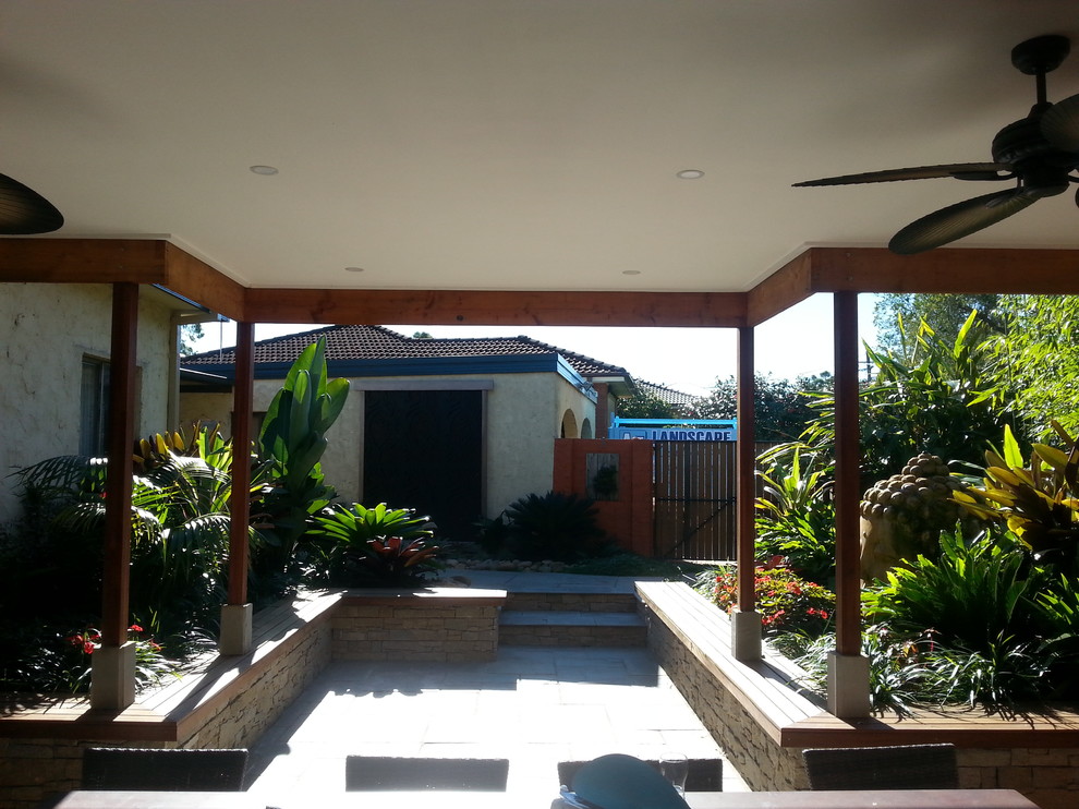 Foto di un giardino tropicale dietro casa e di medie dimensioni con pavimentazioni in pietra naturale e fontane