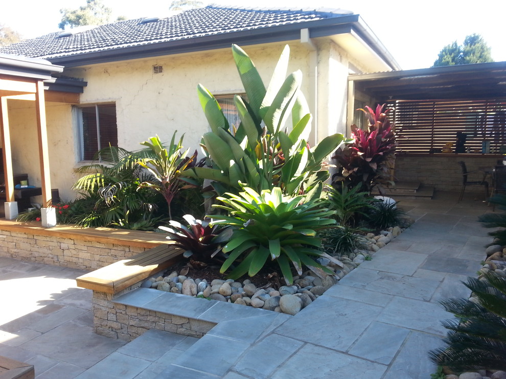 Mittelgroßer Garten hinter dem Haus mit Natursteinplatten und Wasserspiel in Sydney