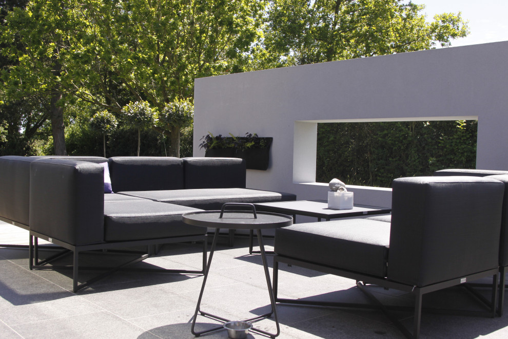 Пример оригинального дизайна: большой солнечный, летний регулярный сад на заднем дворе в стиле модернизм с хорошей освещенностью и покрытием из каменной брусчатки