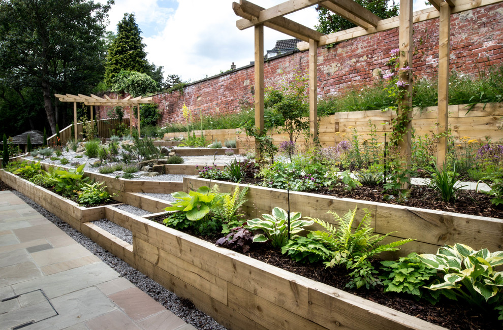 Cette image montre un jardin arrière design de taille moyenne et l'été avec une exposition ombragée et des pavés en pierre naturelle.
