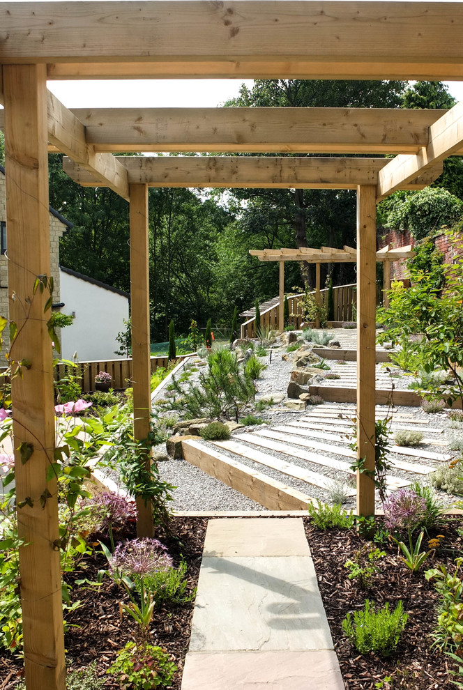 Cette image montre un jardin arrière design de taille moyenne et l'été avec une exposition ombragée et des pavés en pierre naturelle.