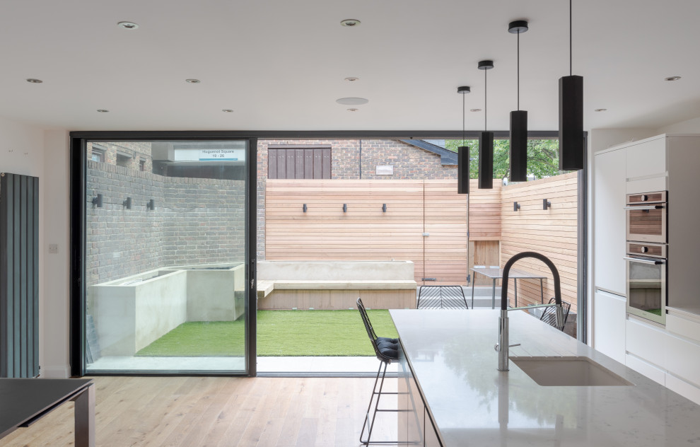 Geometrischer, Kleiner, Halbschattiger Moderner Garten hinter dem Haus mit Sichtschutz und Holzzaun in London