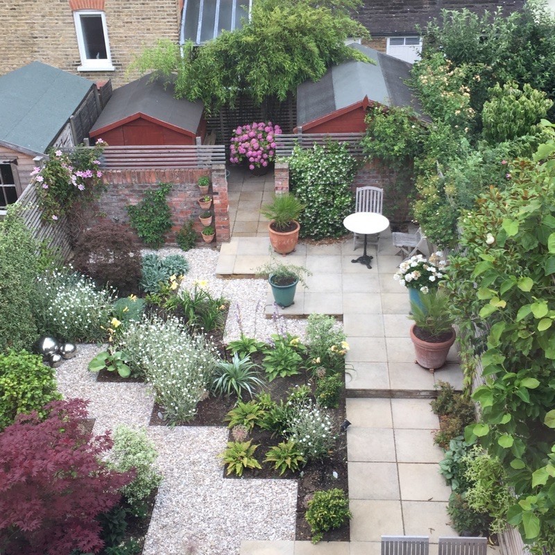 Design ideas for a small contemporary back formal partial sun garden for summer in London with gravel.