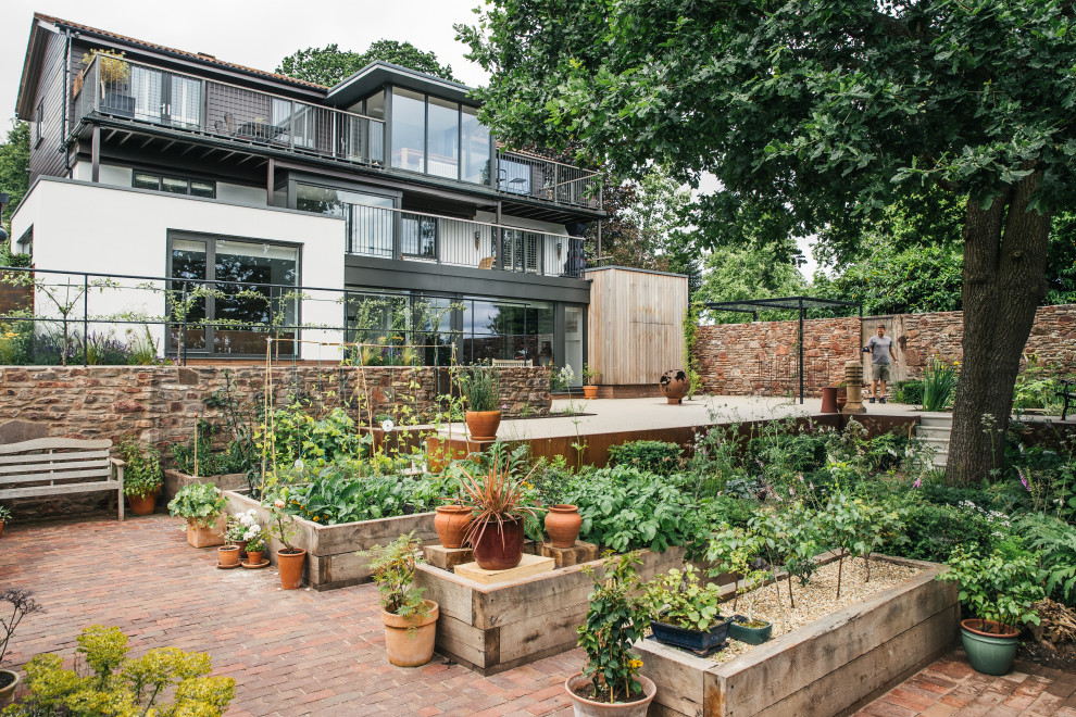 Foto di un grande giardino design esposto in pieno sole dietro casa in estate con ghiaia