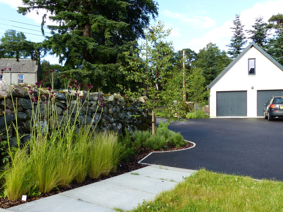 Inspiration för en mellanstor funkis uppfart i delvis sol framför huset på sommaren, med en trädgårdsgång och marksten i betong