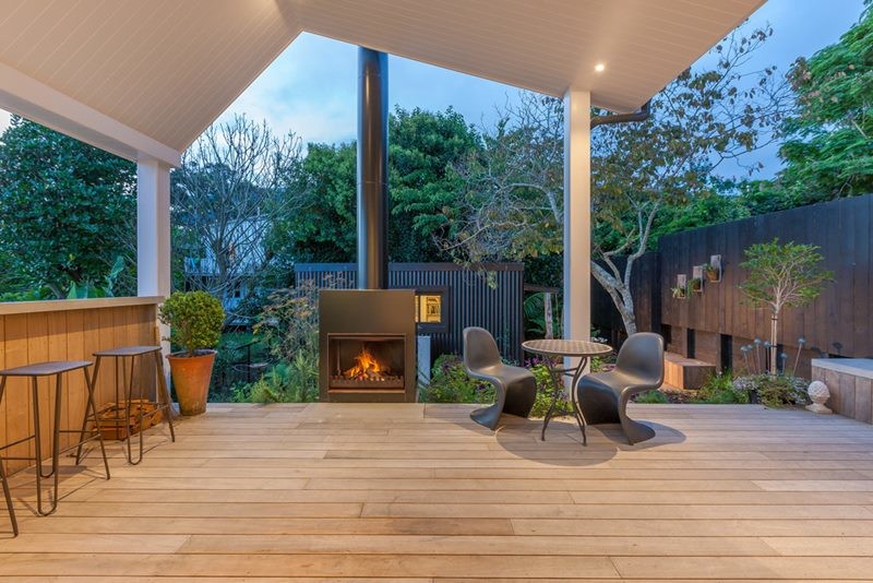Inspiration pour un jardin arrière design de taille moyenne avec un foyer extérieur, une exposition ensoleillée et une terrasse en bois.