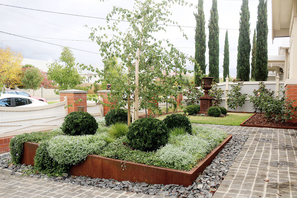 Diseño de jardín moderno de tamaño medio en primavera en patio delantero con jardín francés, jardín de macetas, exposición total al sol y mantillo