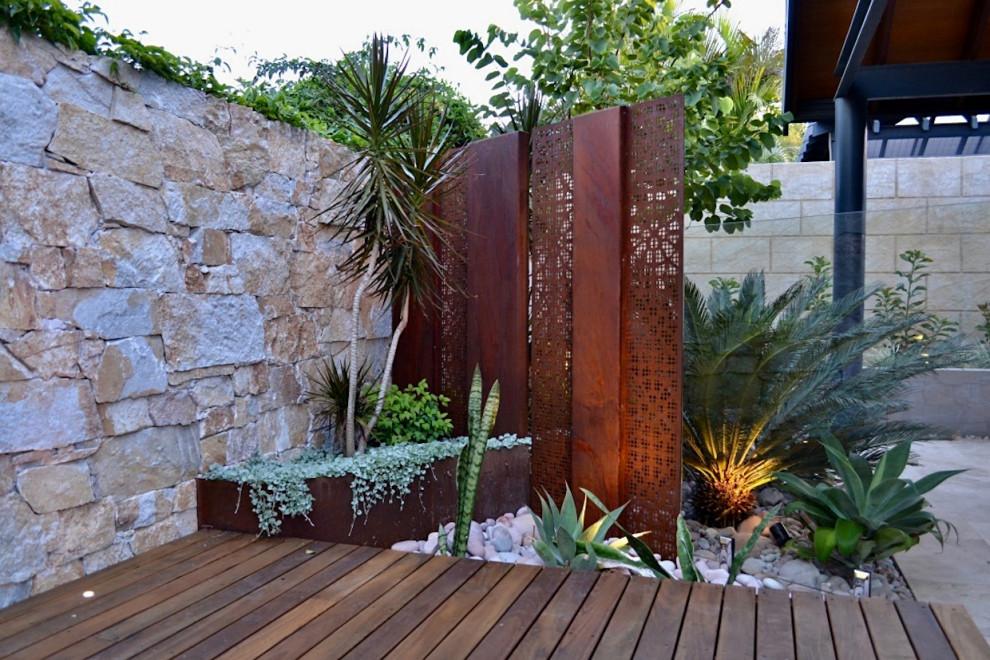 Photo of a small contemporary drought-tolerant and partial sun backyard raised garden bed in Perth with decking for summer.