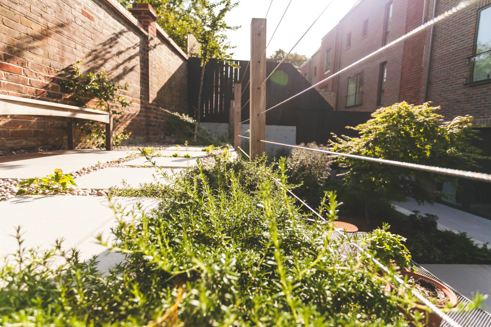 На фото: тенистый, летний регулярный сад среднего размера на заднем дворе в современном стиле с подпорной стенкой и мощением клинкерной брусчаткой с
